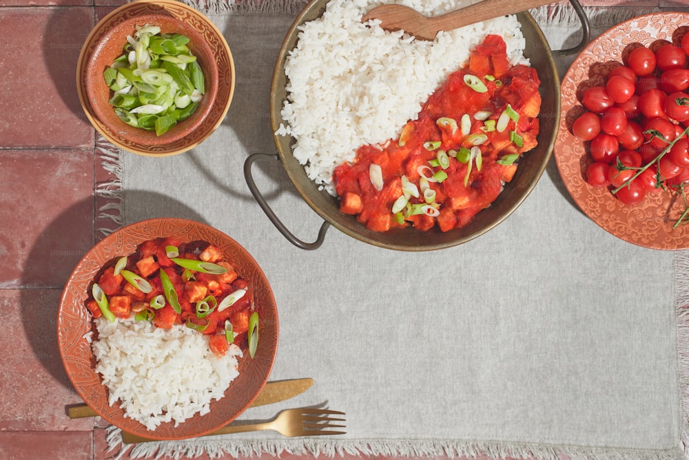 una mesa cubierta con cuencos llenos de arroz y verduras