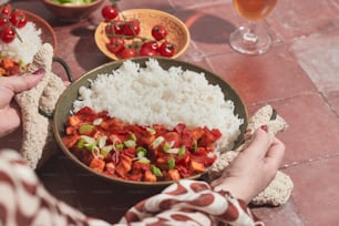 a person holding a bowl of food on a table