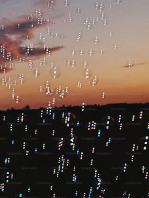 a sky filled with lots of bubbles next to a sunset