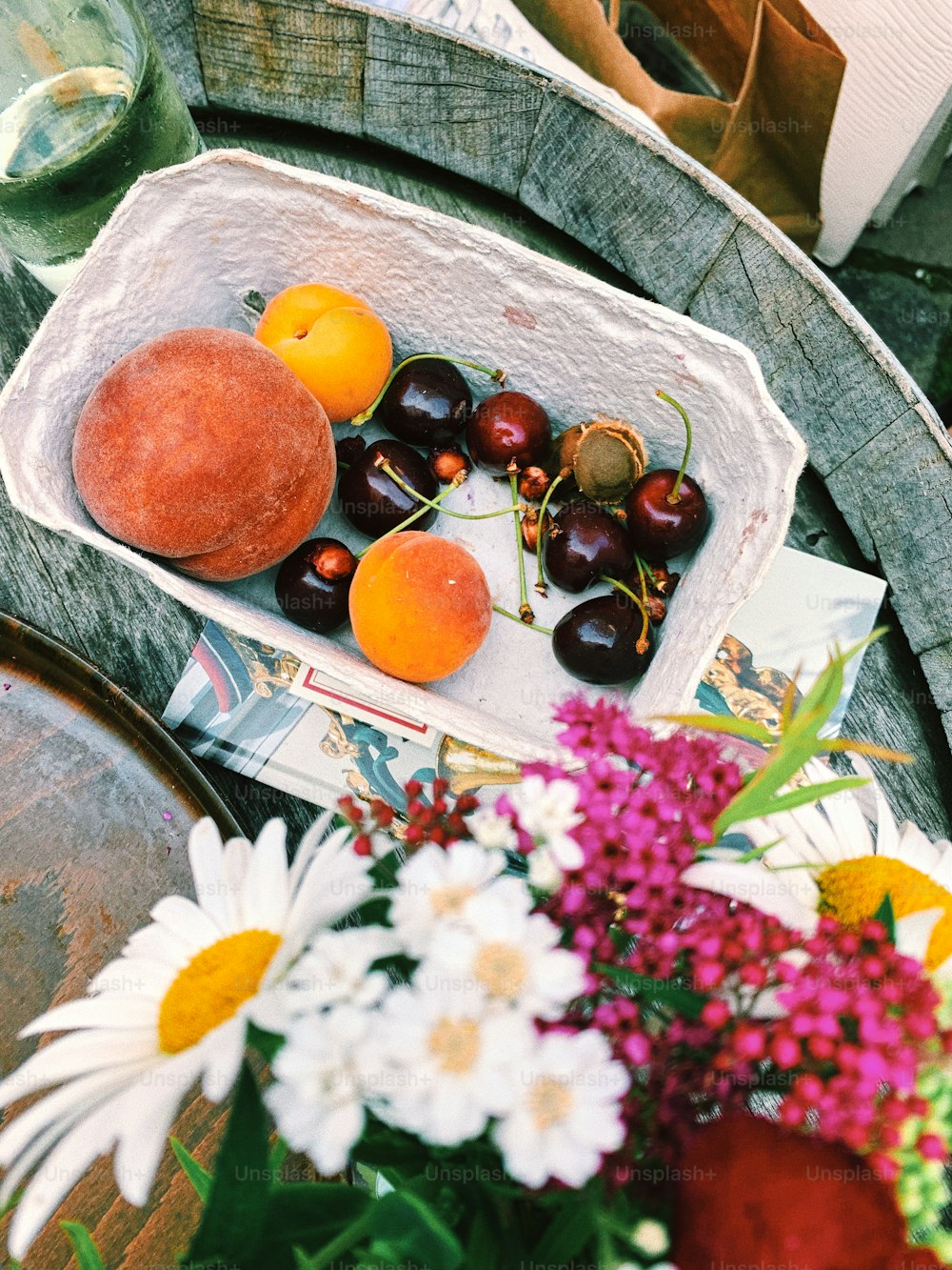 una cesta llena de cerezas y naranjas encima de una mesa