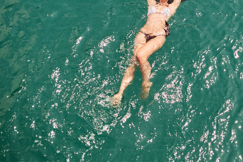 uma mulher em um biquíni nadando no oceano