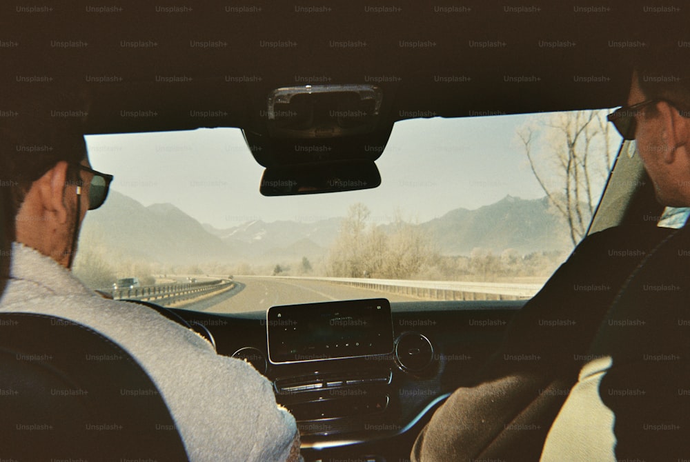 a man driving a car while holding a cell phone