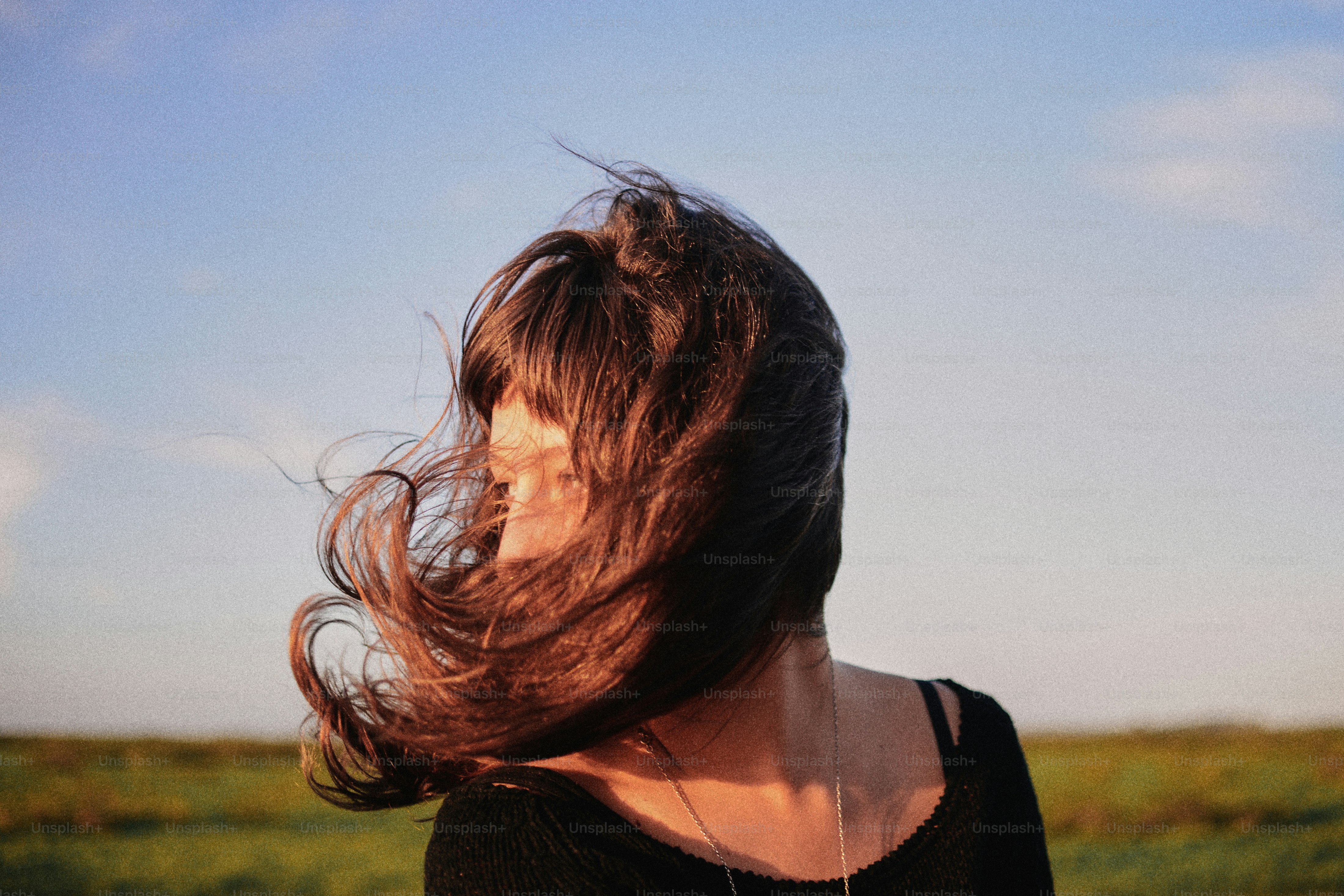 a woman with her hair blowing in the wind