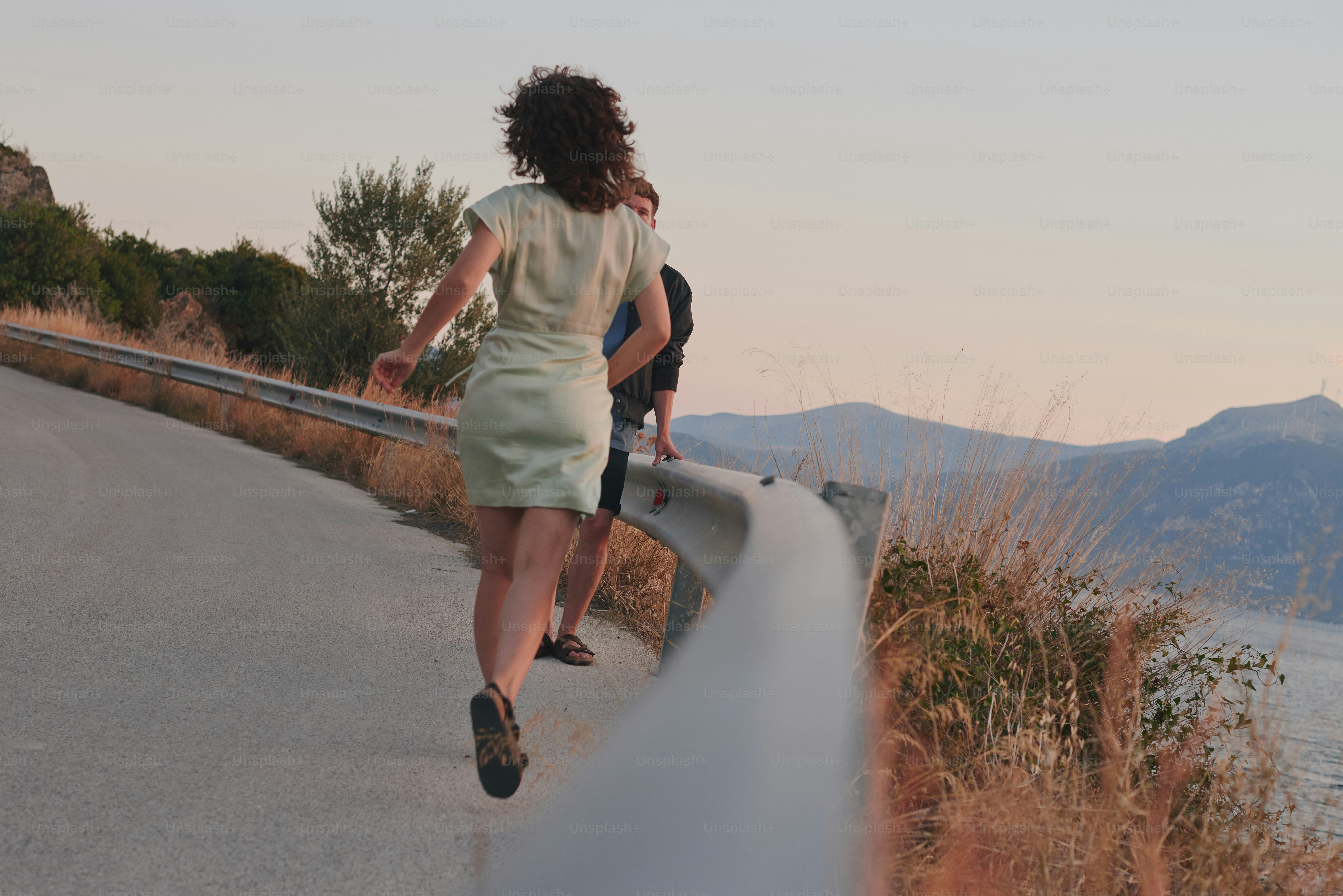 une femme marchant sur une route avec une planche à roulettes