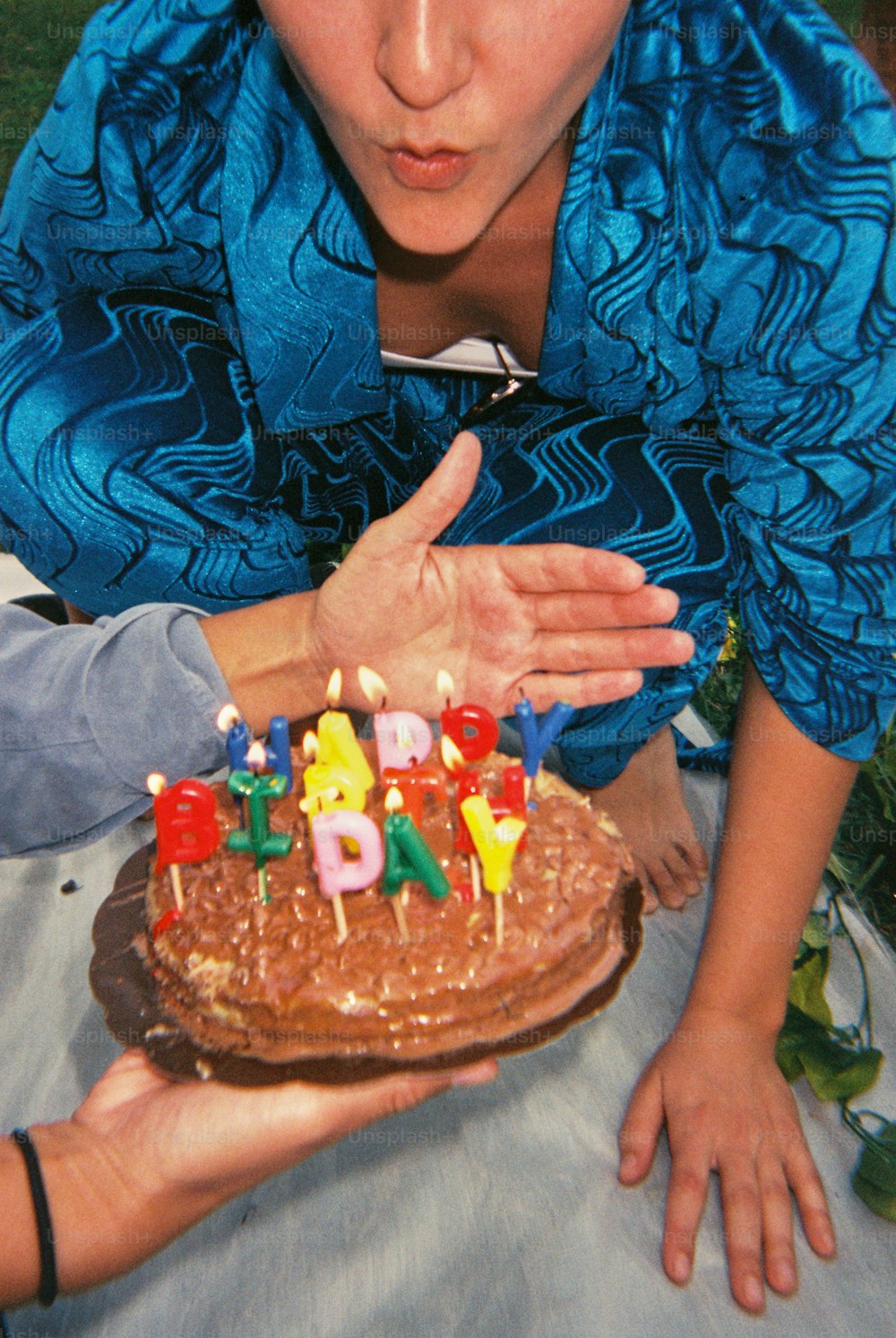 a woman holding a cake with candles on it
