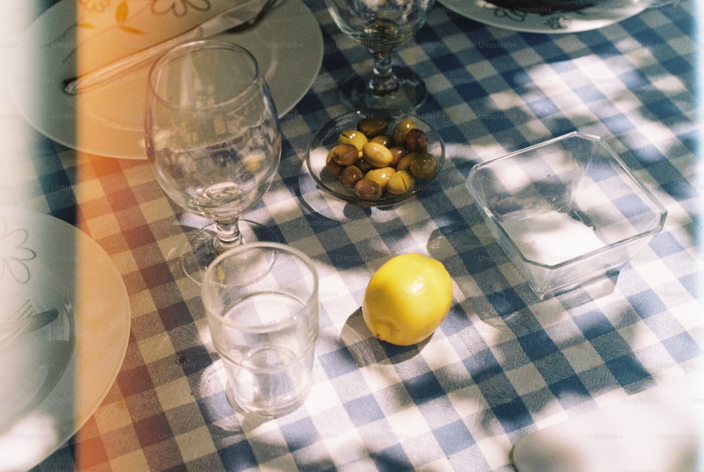 레몬 옆에 접시와 유리잔이 놓인 테이블