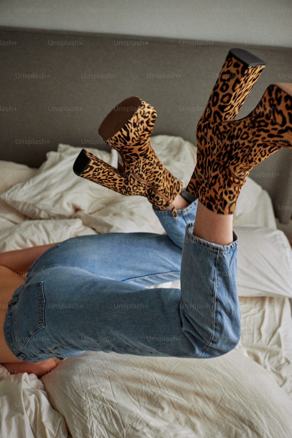 a person laying on a bed with their feet in the air