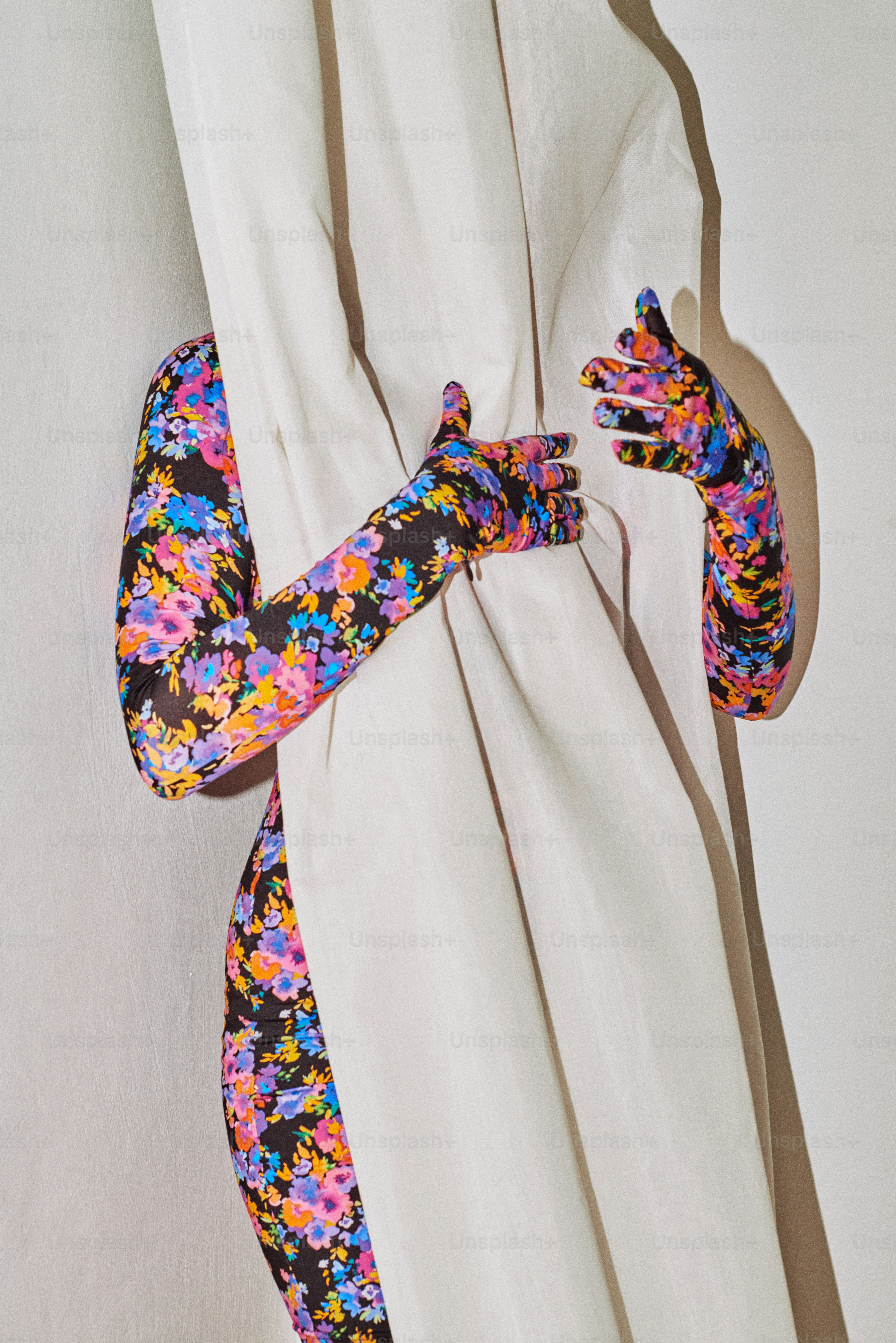 o braço de uma mulher enrolado em torno de uma cortina branca