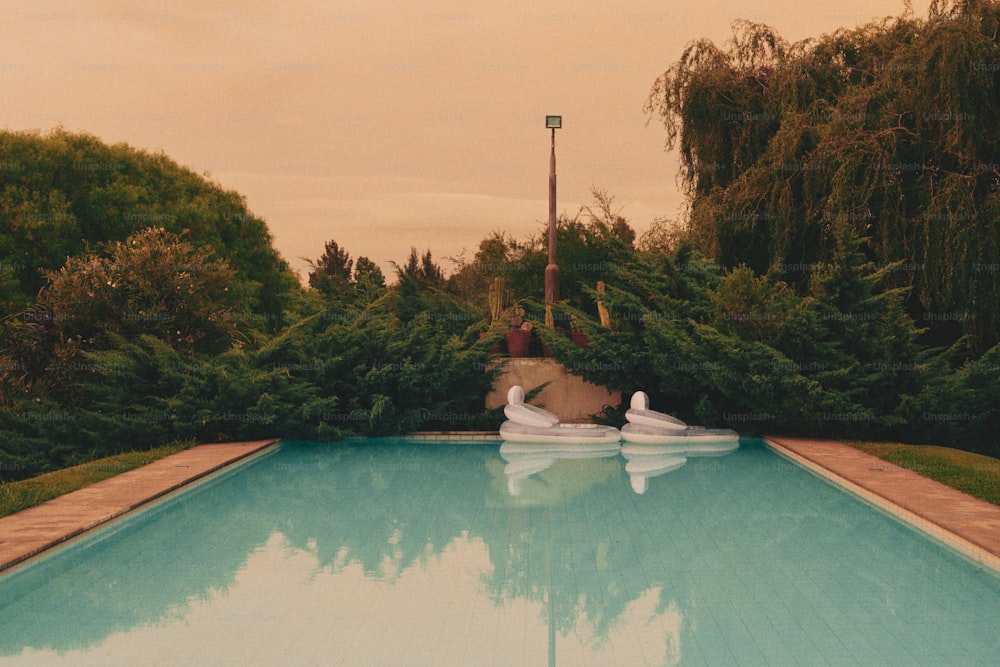 a large swimming pool with a person sitting on the edge of it