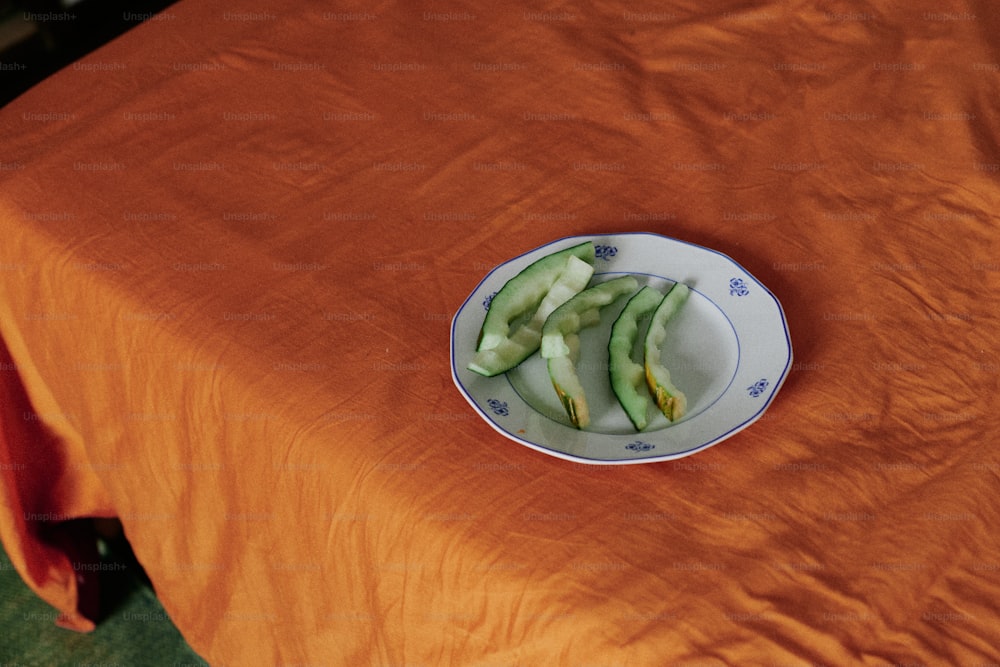 a plate of sliced cucumbers on an orange table cloth