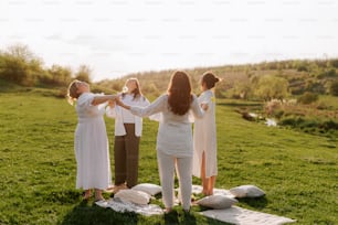 a group of women standing on top of a lush green field