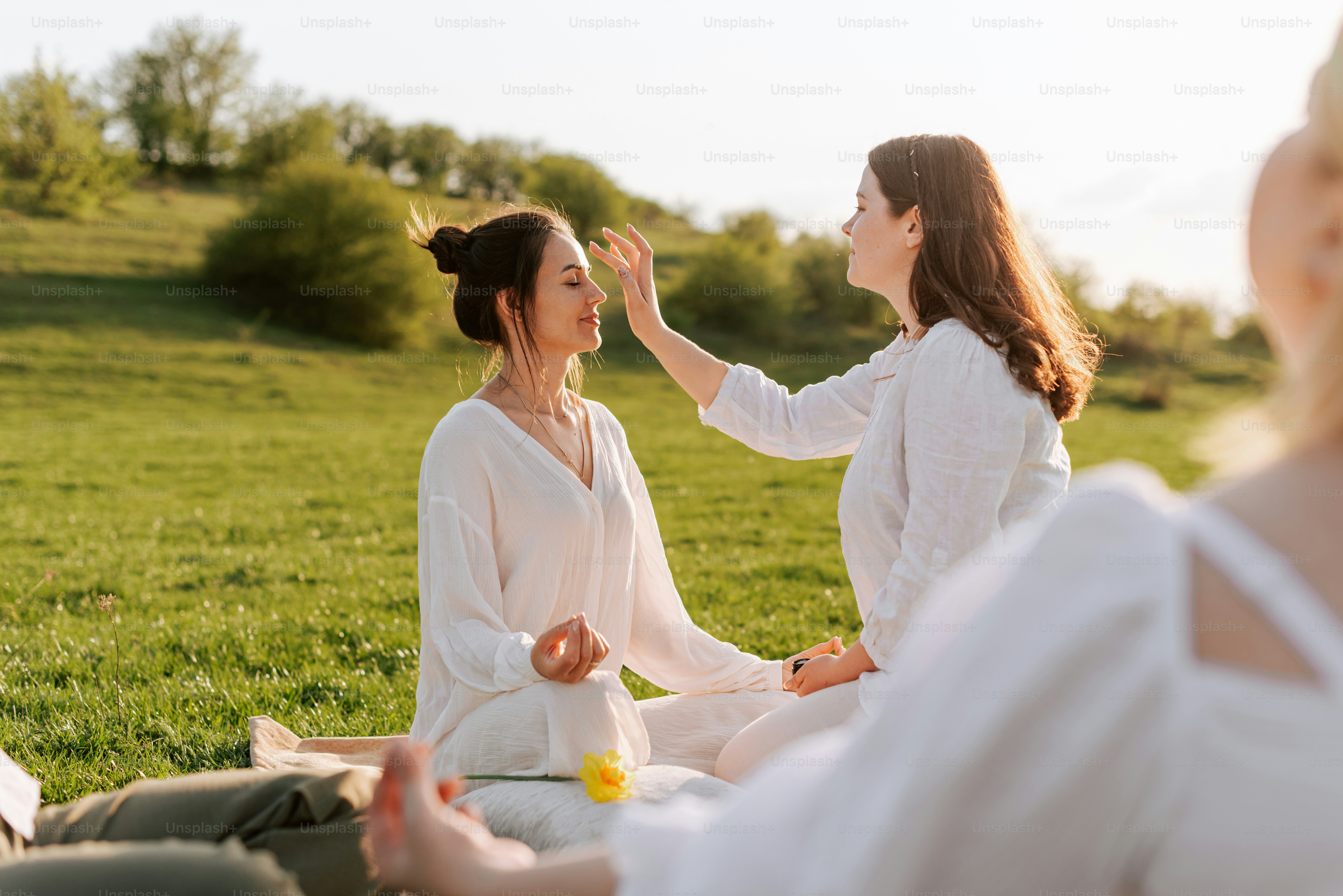 Two women sitting on the ground in a field photo – Outdoor Image on ...