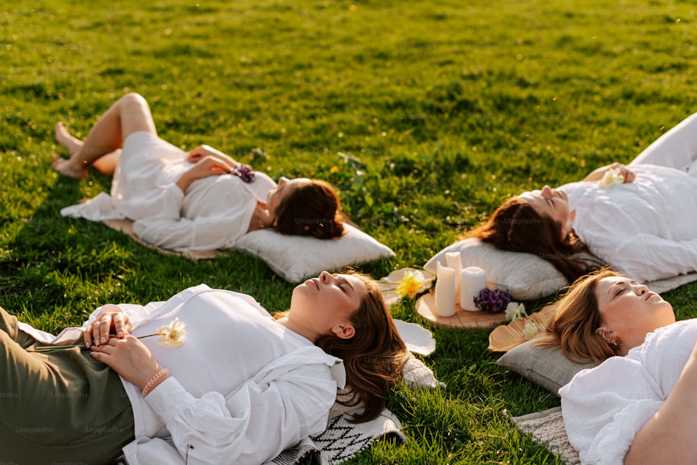 青々とした緑の野原の上に横たわる女性たち