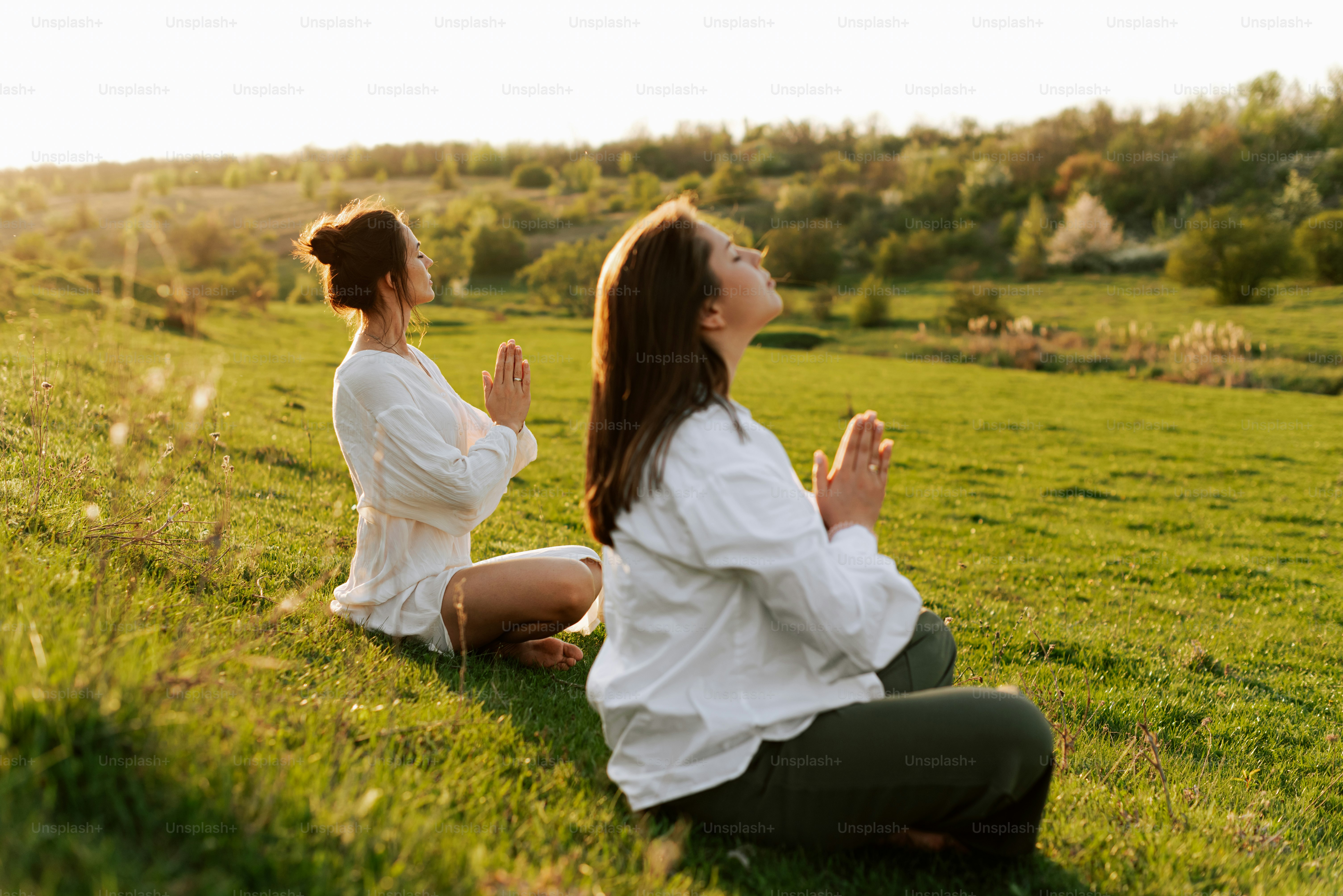 um casal de mulheres sentadas em cima de um campo verde exuberante