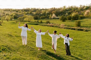 a group of women standing on top of a lush green field