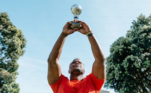 a man holding up a trophy in the air