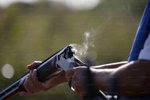 una persona sosteniendo un arma de la que sale humo