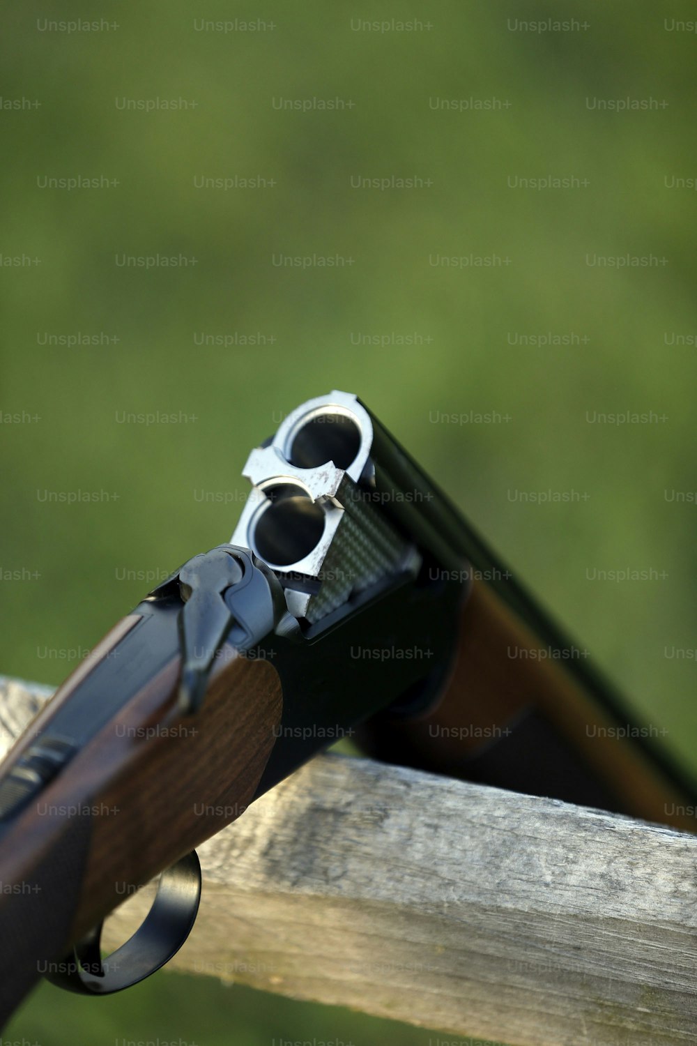 um close up de uma arma em um trilho de madeira