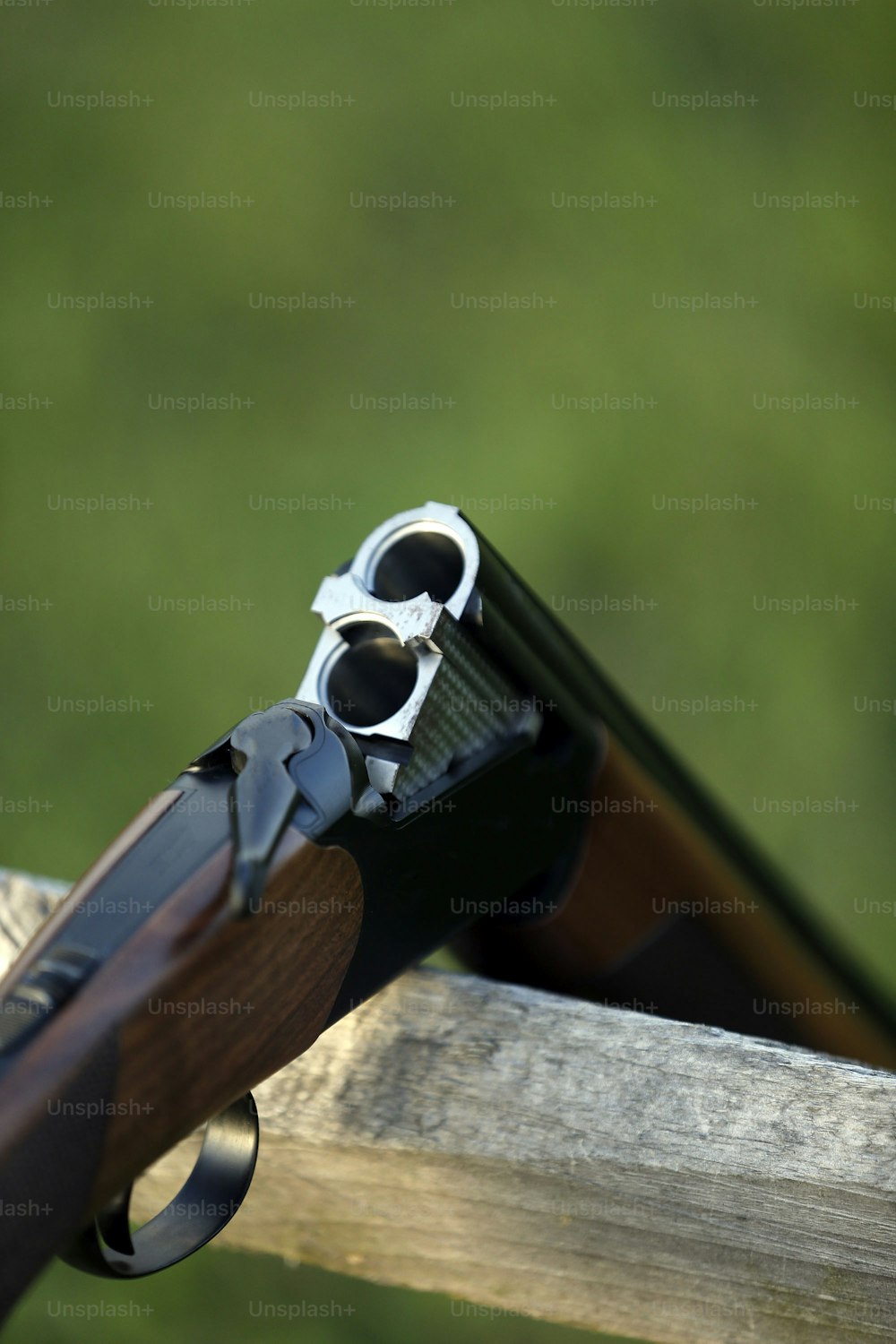 a close up of a gun on a wooden rail