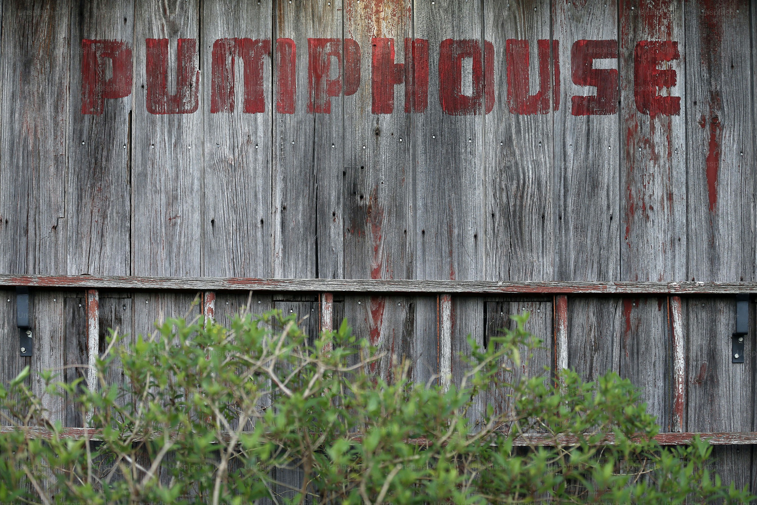 a wooden building with a red word painted on it