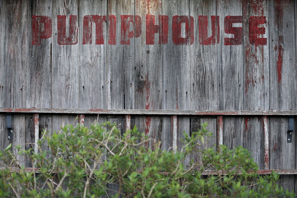 a wooden building with a red word painted on it