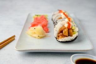 une assiette de sushis et des baguettes sur une table