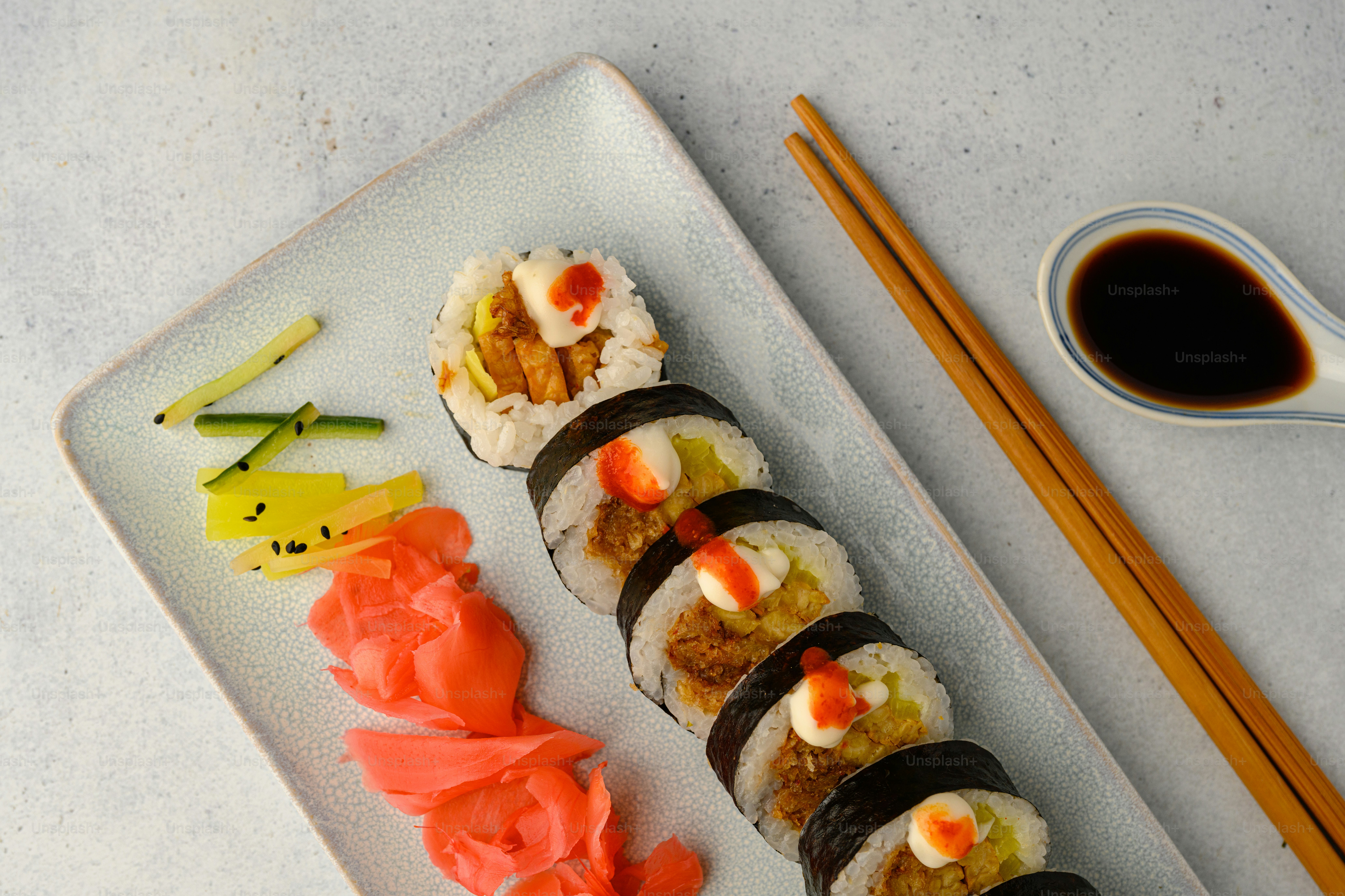 a plate of sushi and chopsticks on a table