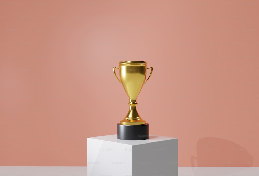 a golden trophy sitting on top of a white pedestal