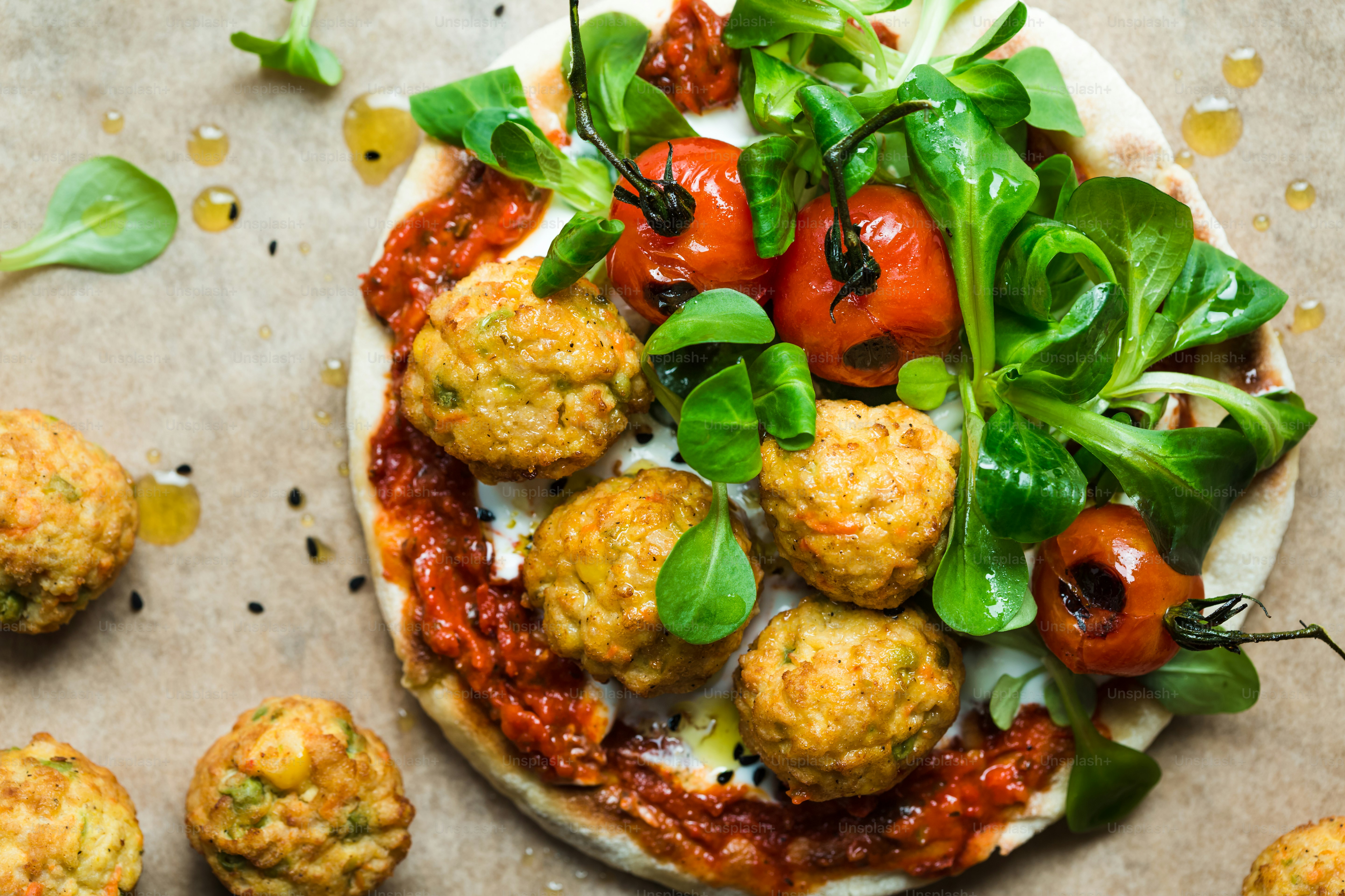 eine Pizza mit Fleischbällchen und Gemüse