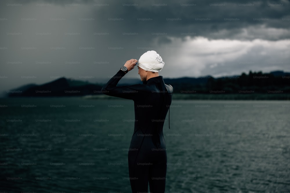a woman in a wet suit standing on a beach