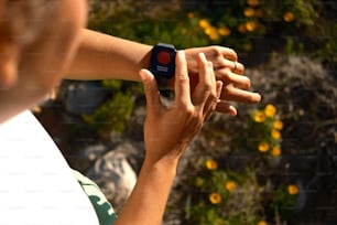 eine Person, die eine Smartwatch in der Hand hält