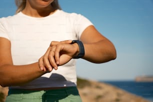 a woman in a white shirt is holding her wrist