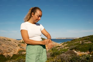 a woman in white shirt and green shorts holding her hands together