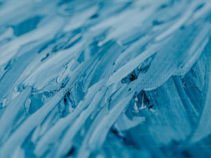 a close up picture of blue paint with drops of water on it