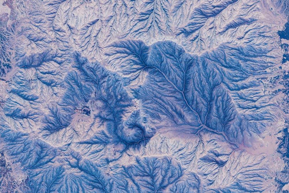 an aerial view of a mountain range in the snow
