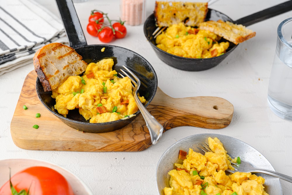 scrambled eggs in a skillet on a cutting board