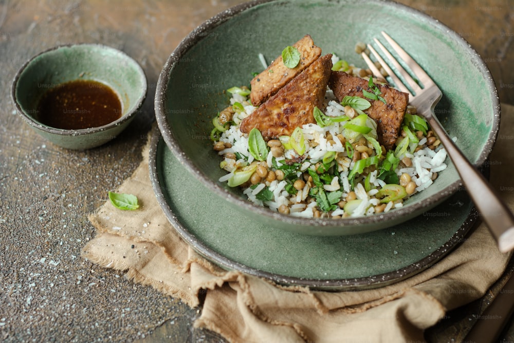 a green bowl filled with rice and meat