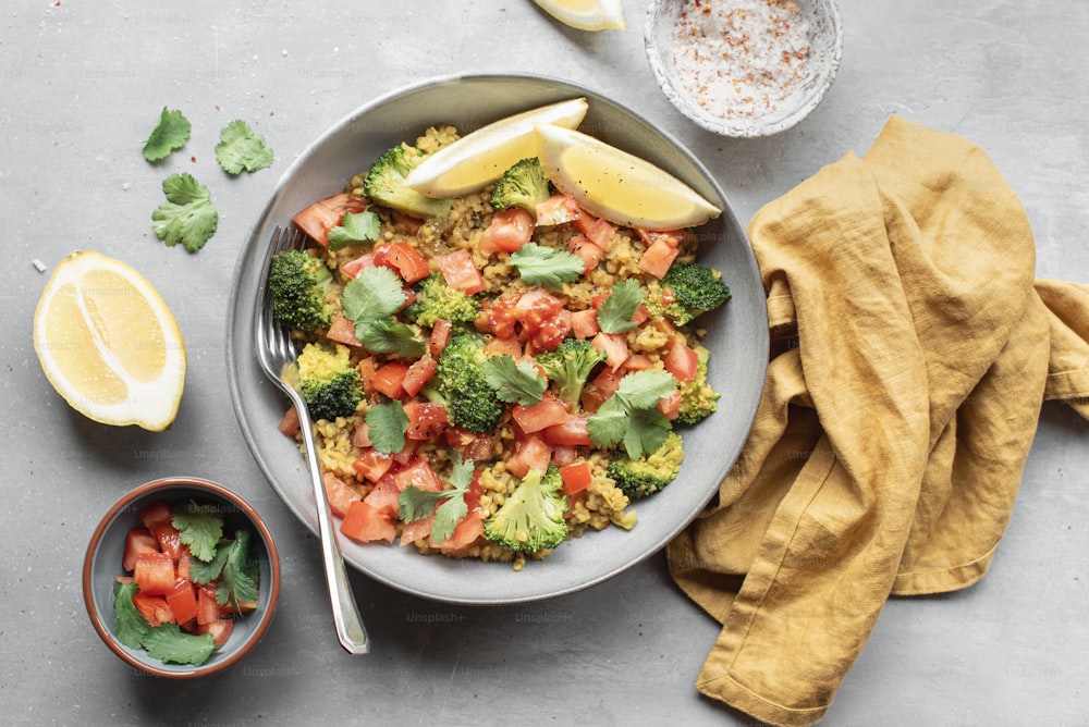 a bowl filled with broccoli, tomatoes, and other vegetables