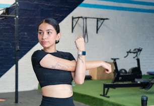 a woman with a tattoo on her arm in a gym