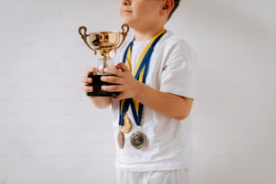 a young boy holding a trophy in his hands