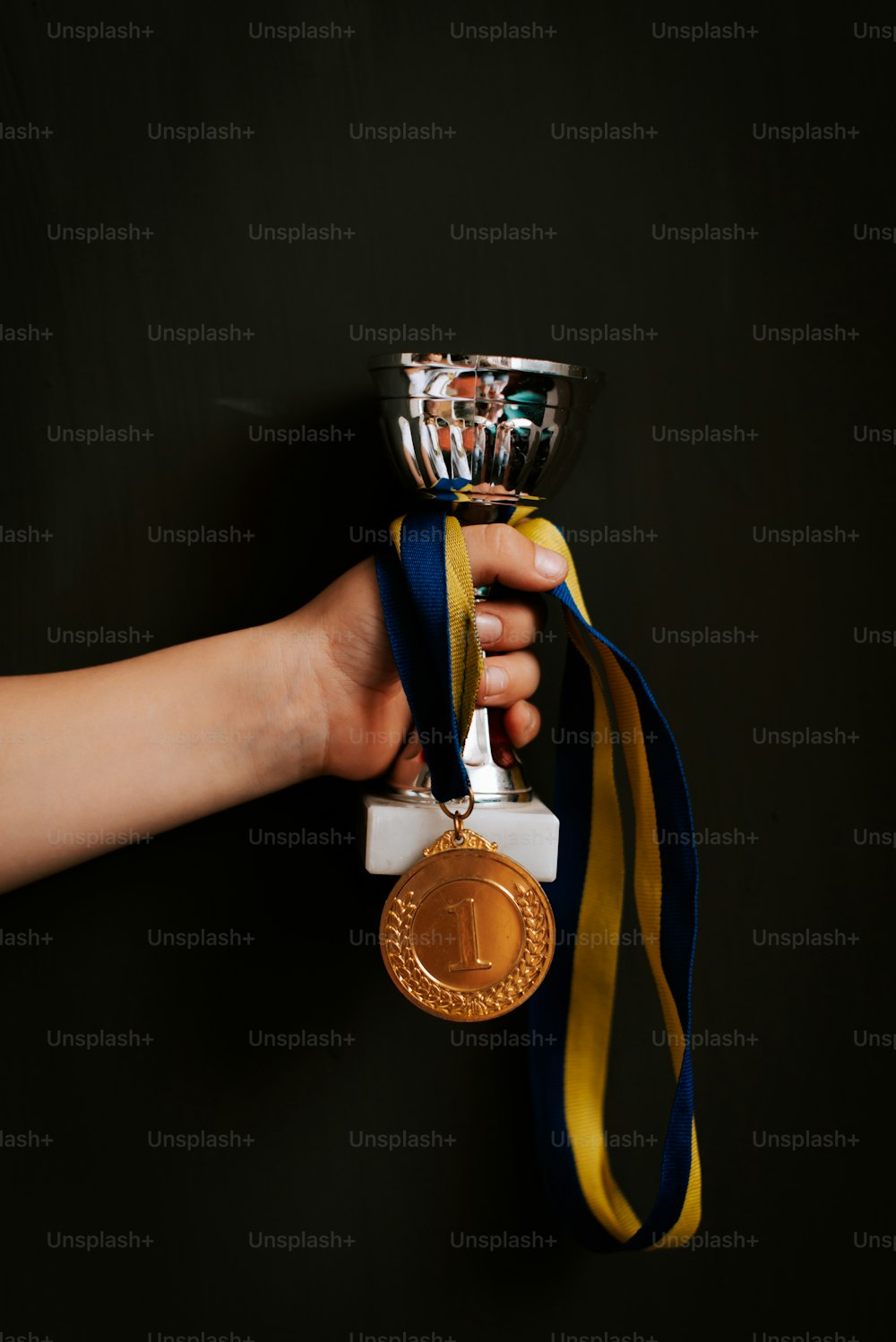 una persona que sostiene una medalla de oro en la mano