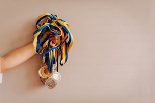 a person's hand holding a medal and a ribbon