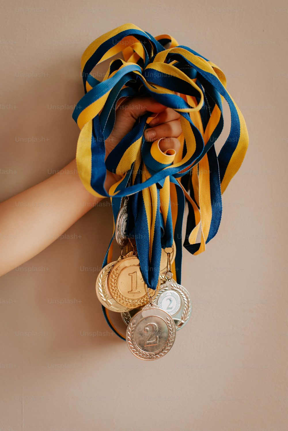 a woman's hand holding a medal and a ribbon