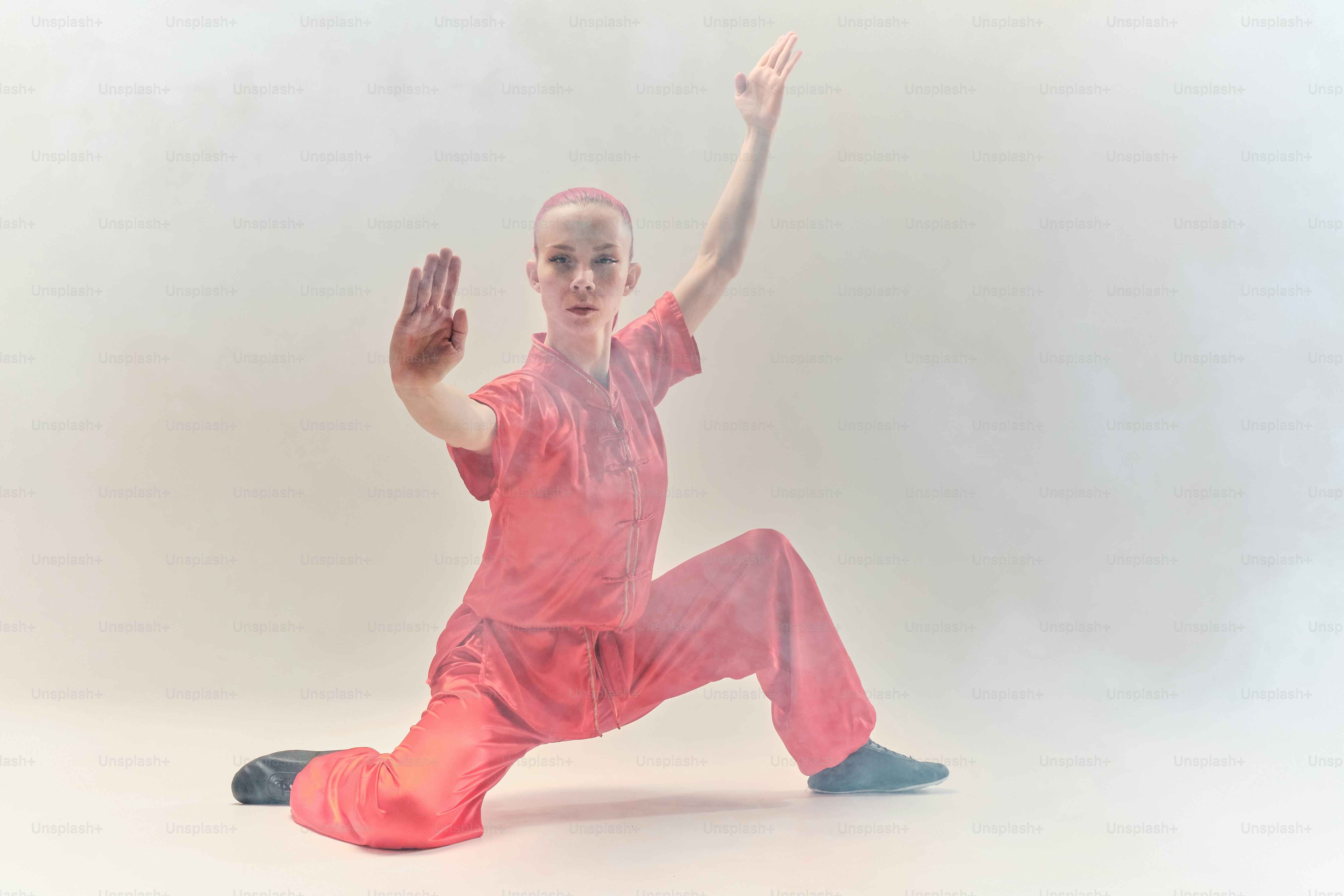 a boy in a pink outfit is doing a dance move