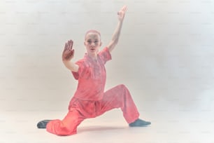 Ein Junge in einem rosa Outfit macht eine Tanzbewegung