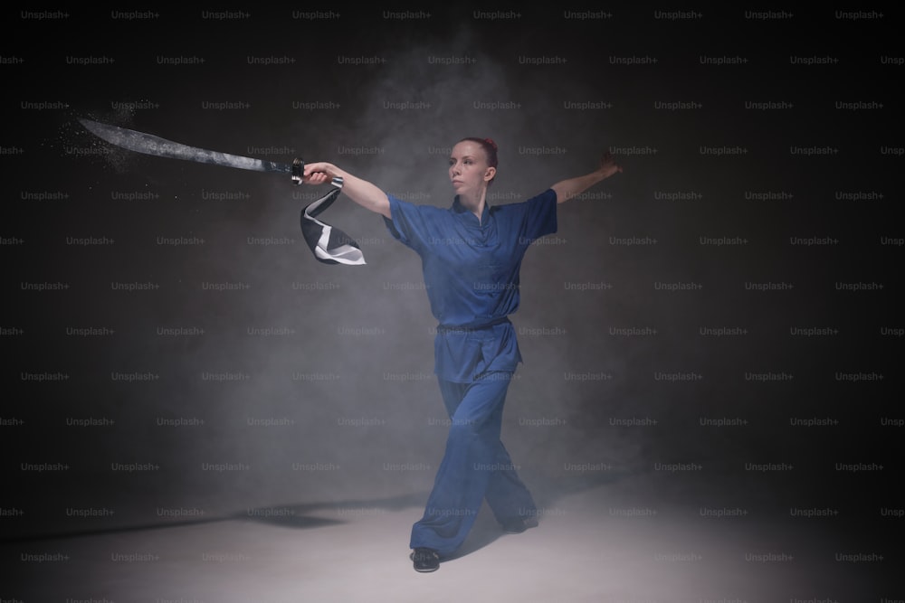 a woman in a blue jumpsuit holding a baseball bat
