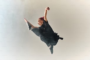 a woman flying through the air while wearing a black dress