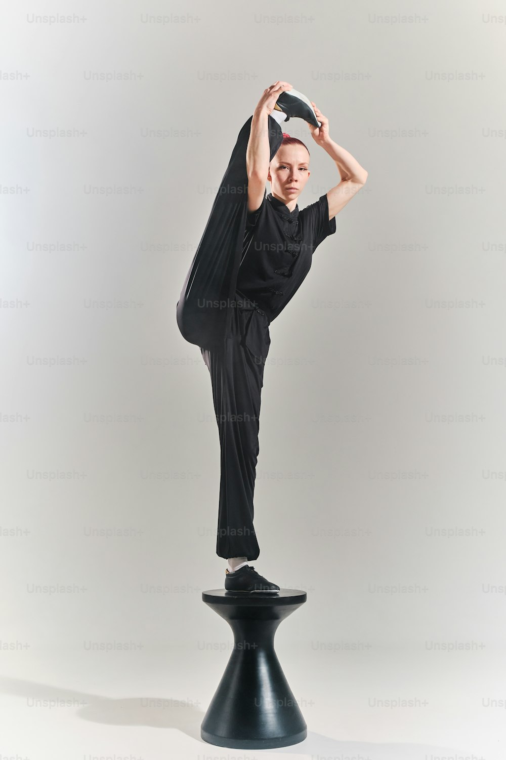 a woman is doing a yoga pose on a stool