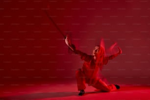 a woman in a red outfit is holding a sword