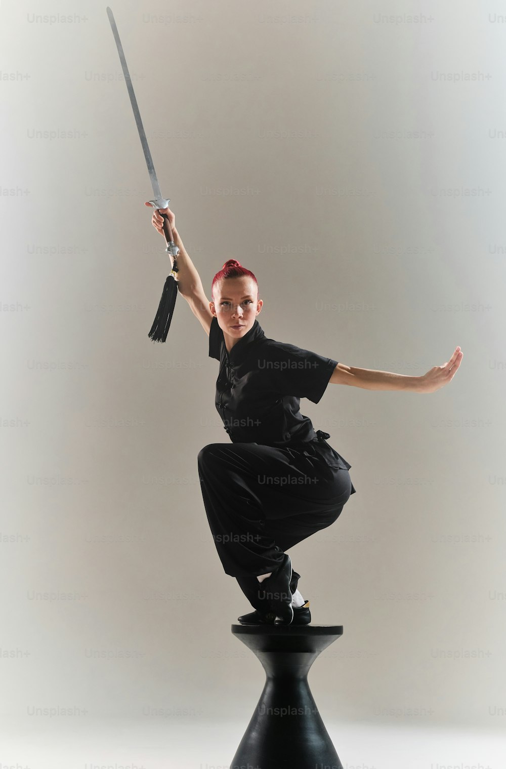 a woman in a black shirt is holding a sword